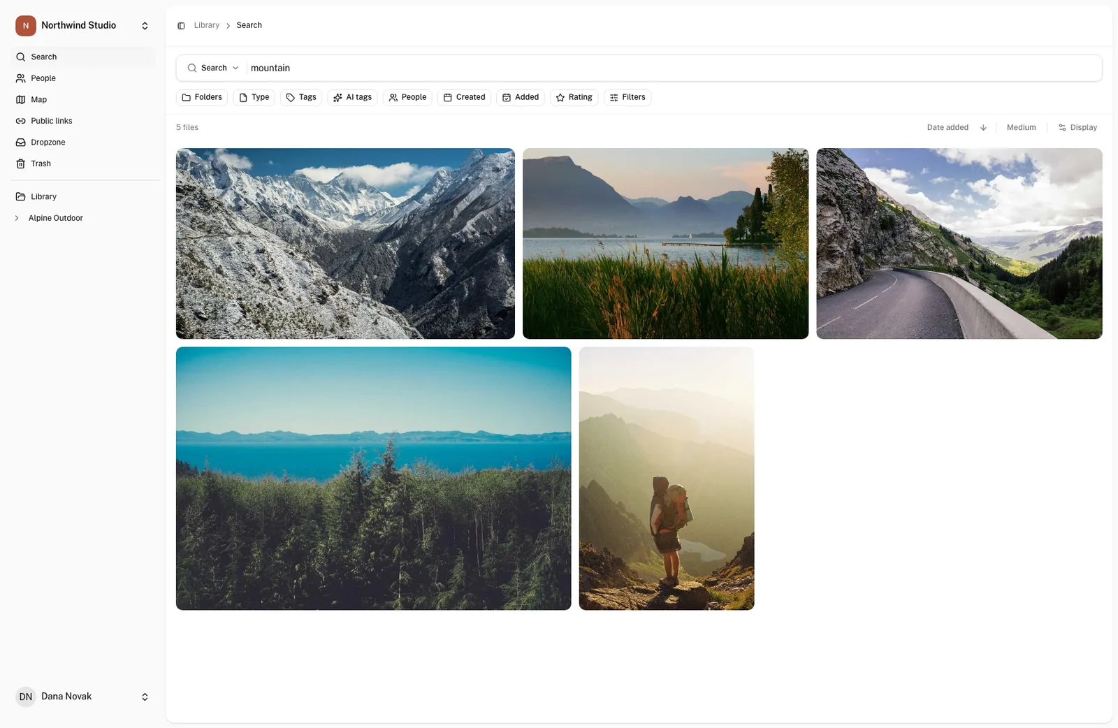 Rezultati iskanja besede mountain v OLO: pet fotografij vrhov, gorske ceste, jezera pod grebenom in pohodnika nad dolino.